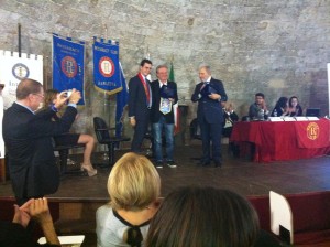 L'RD Ettore Mario Peluso che consegna a Costantino Foschini e Antonio Caprarica il "Premio Rotaract per la comunicazione".